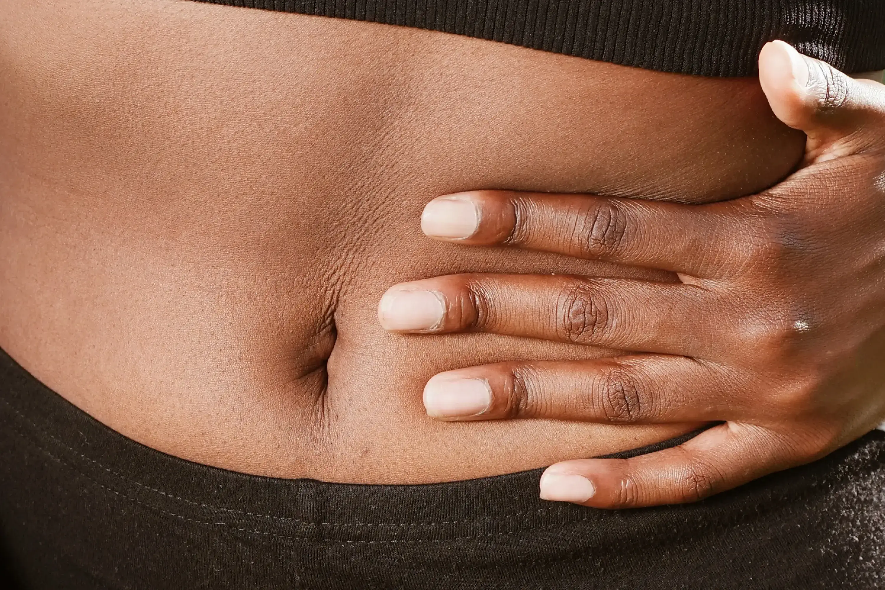 a hand pressing on their stomach